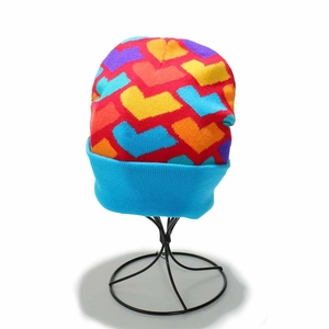 Detailed view of colorful knit heart patterns and blue ribbed cuff on a red beanie