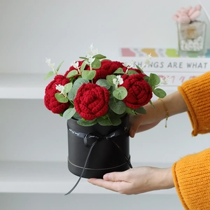 Handcrafted crochet red roses in black gift box held by hands for Valentine gift