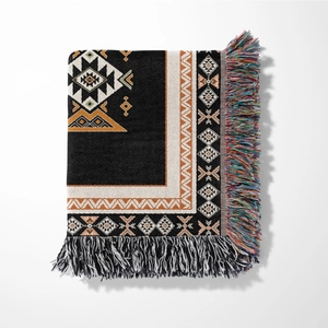 Detail of tribal pattern blanket with geometric motifs and colorful bohemian tassels