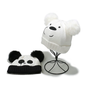 Détail de bonnets panda tricotés pour enfants avec pompons en fausse fourrure douce
