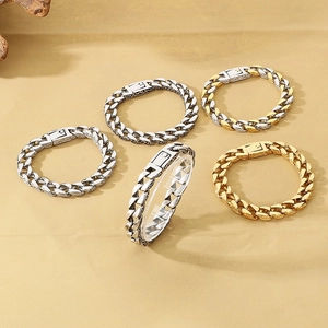 Detailansicht von Vintage-Panzerarmbändern in Silber und Gold auf einem Displayständer