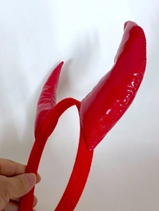 Détail du serre-tête cornes de diable rouges en similicuir brillant et base en tissu