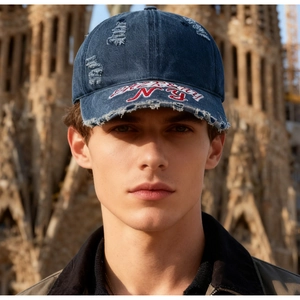 Gros plan sur casquette vintage en denim avec broderie NY et bordure effet usé