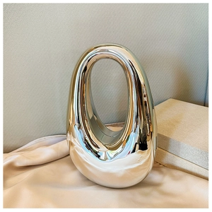 Close-up of sleek silver acrylic shell clutch bag with metallic mirror finish detail