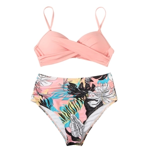 Pink wrap bikini top and high-waisted tropical print bottoms set on white background
