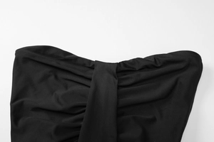 Detail view of ruched black fabric with elegant knot design and smooth soft texture