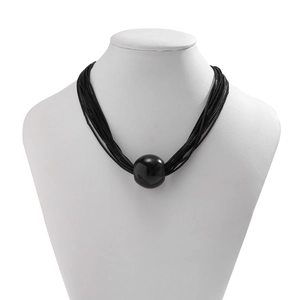 Detail of layered black multi-strand chain necklace with large round bead on a white mannequin