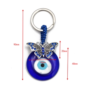 Detailed view of evil eye keychain with blue butterfly and clear 90mm size measurements