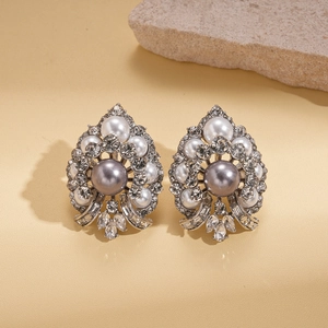Vintage geometric floral stud earrings with grey pearls and crystals on leather backdrop