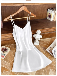 Détail d'une nuisette en satin blanc sur un cintre en bois avec fond de bibliothèque vintage