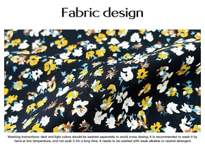 Close-up detail of soft black fabric with yellow, white and blue floral print patterns