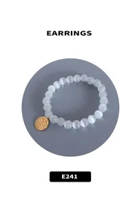 Detail view of a cat's eye stone bracelet with a gold 'Fu' character lucky pendant charm