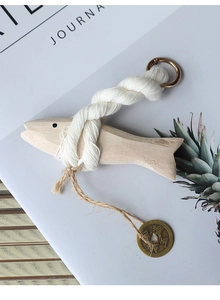 Detail of wooden fish carving with cotton rope and engraved antique bronze coin decoration