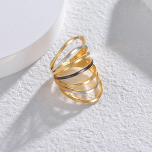 Close-up of a multilayered geometric ring with gold, silver, and black matte finish