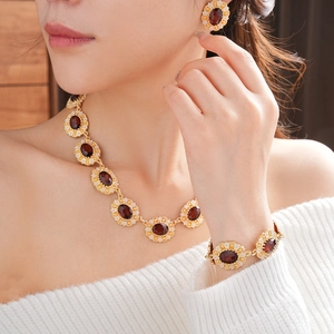 Detailed view of vintage jewelry set with oval red gemstones and gold metal finish
