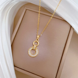 Close-up of interlocking gold rings necklace with white zircon pavé on jewelry box