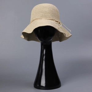 Close-up of handmade cream straw sun hat with fine crochet weave and delicate bow detail