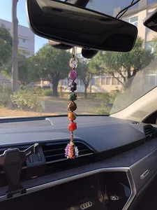 Detailed close-up of a handmade 7 chakra natural stone hanging ornament inside a vehicle