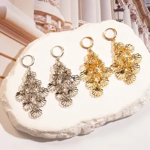 Gold and silver shell leaf earrings with tassel diamonds on stone display