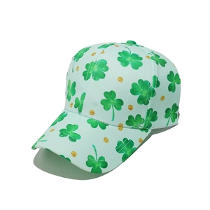 Detailed view of mint green baseball cap featuring festive clover prints and gold glitter dots