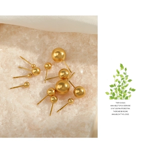 Detail view of gold round stud earrings in various sizes on sparkling crystal base