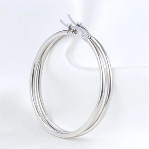 Detailed close-up of 50mm triple-layered silver stainless steel hoop earrings on white silk
