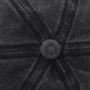 Gros plan du bouton supérieur et des coutures sur casquette en coton lavé noir