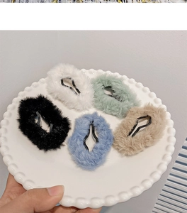 Detailed view of five plush cloud hair clips in multiple pastel colors on a white plate