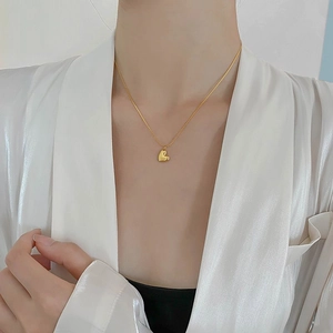 Elegant gold heart pendant necklace on model with minimalist 18K plated stainless steel chain