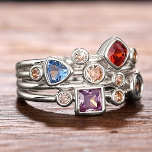 Primer plano de un anillo de plata multicapa con piedras preciosas geométricas de colores