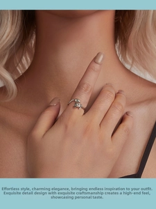 Detail of s925 silver snake and rose ring with green gemstone eyes on model finger