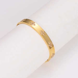 Luxurious gold-plated stainless steel bangle with inlaid zircons and clover motifs