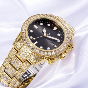 Detailed close-up of gold iced-out watch with green sunray dial on white silk