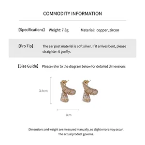 Detail view of gold bow earrings with drop zircons showing 3.4cm by 1cm dimensions