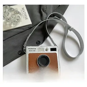 Detailed view of silver and brown camera shaped bag with influencer cam text design