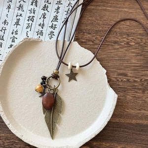 Collier vintage bohème avec pendentifs plume et étoile sur cordon avec perles en bois