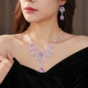 Detail of vintage silver necklace set with purple zircon flowers and teardrop crystals