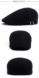 Close-up of black herringbone fabric texture and metal side buckle on newsboy cap