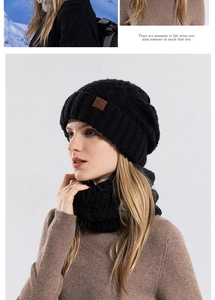 Detail of black winter knit hat and neck gaiter set with thick ribbed texture and logo