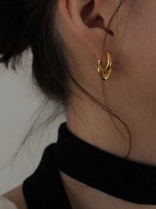 Close-up of elegant gold heart dangle earrings worn by a model to show size and fit