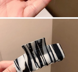 Detail of a french ink pattern acetate hair claw clip with black and white stripes