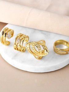 Detailed view of four gold-plated irregular rings with zircons on marble base