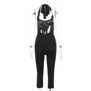 Detail view of the deep V-neck backless design and elastic black fabric of the romper