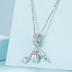 Miniature toothbrush tooth and toothpaste S925 silver charm set on light blue display