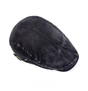 Macro shot of vintage washed black denim flat cap showing stitching and fabric texture