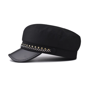 Side profile of black military cap with gold star studs and metal chain detail