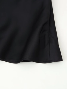 Close-up of black satin hem with professional stitching and smooth fabric texture