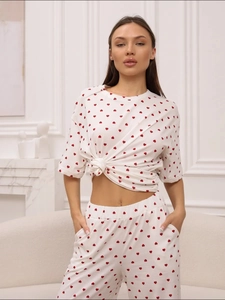Detail view of heart print pajama set featuring a knotted short sleeve t-shirt and long pants