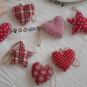 Close-up of heart and star red fabric ornaments with plaid and floral patterns