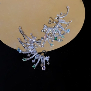 Détail macro de clips d'oreille en zircon coloré reflétés sur un miroir doré poli